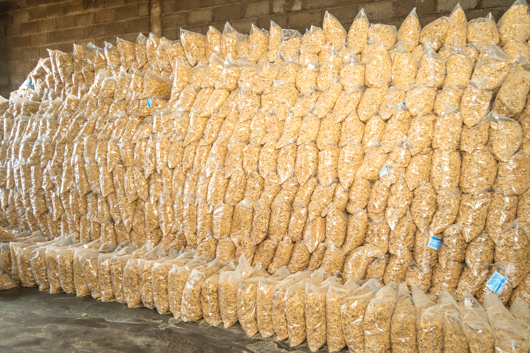 Large wall of packaged soya products stacked inside the warehouse
